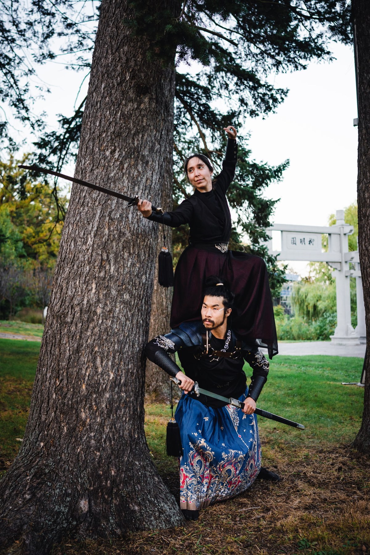 Alex and a companion in costume by a tree.