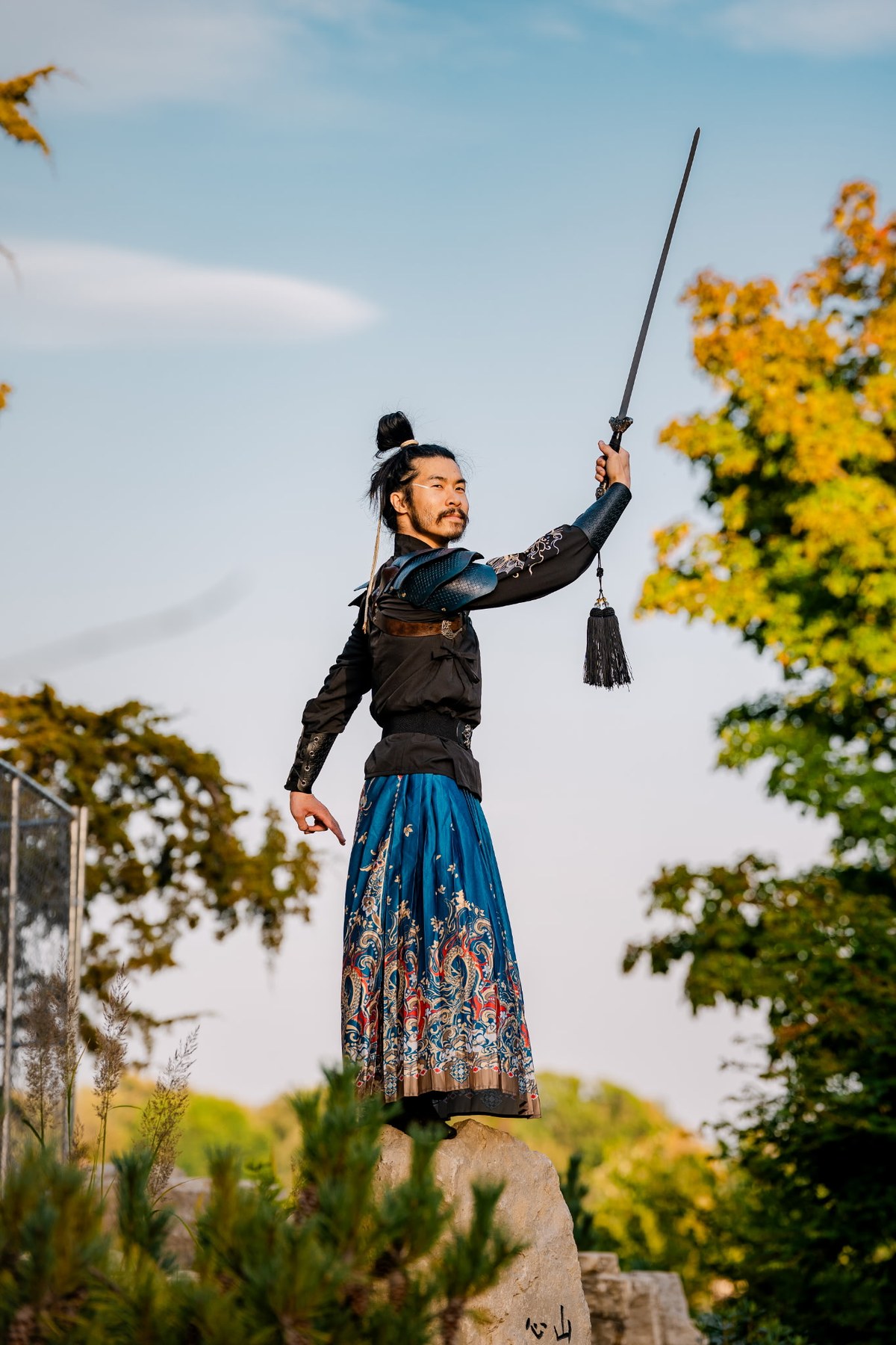 Alex practicing a sword form outdoors.